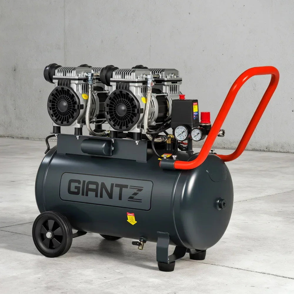 Industrial air compressor with twin motors, large tank, control gauges, and orange handle
