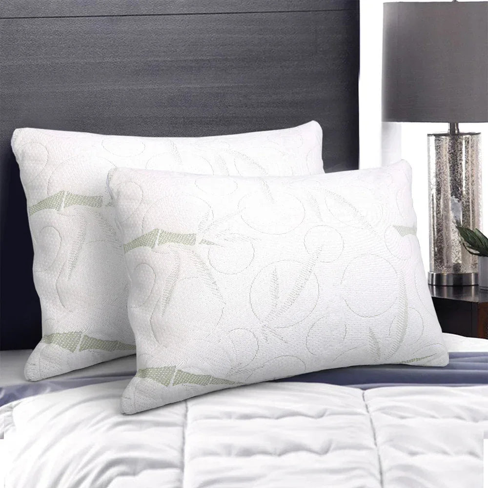 Two white memory foam pillows with subtle patterns on a neatly made bed in a modern bedroom.