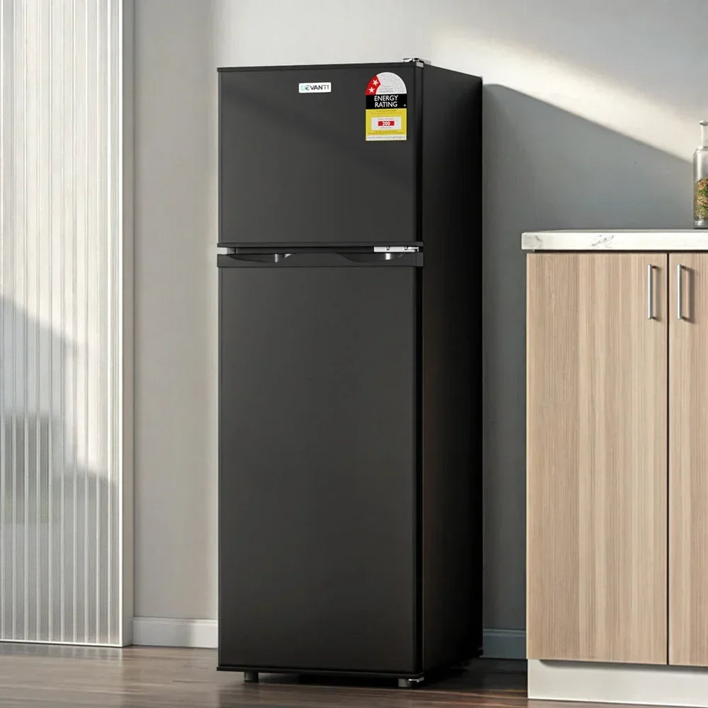 Black two-door top mount refrigerator in modern kitchen setting, energy rating label visible
