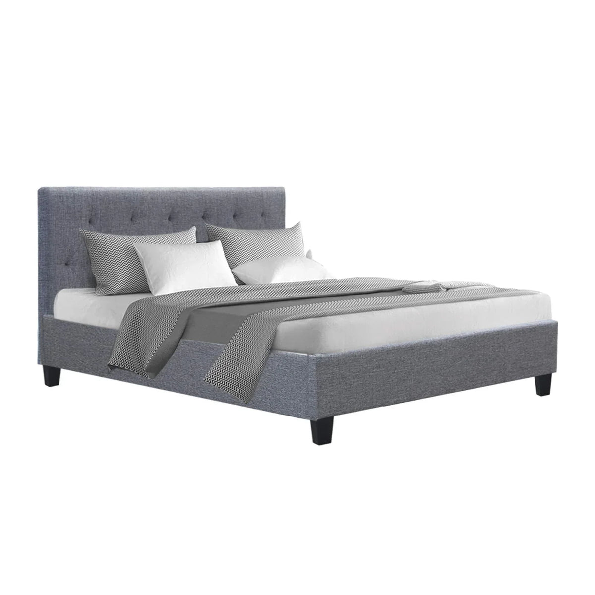 Grey upholstered bed frame with tufted headboard, white and patterned bedding