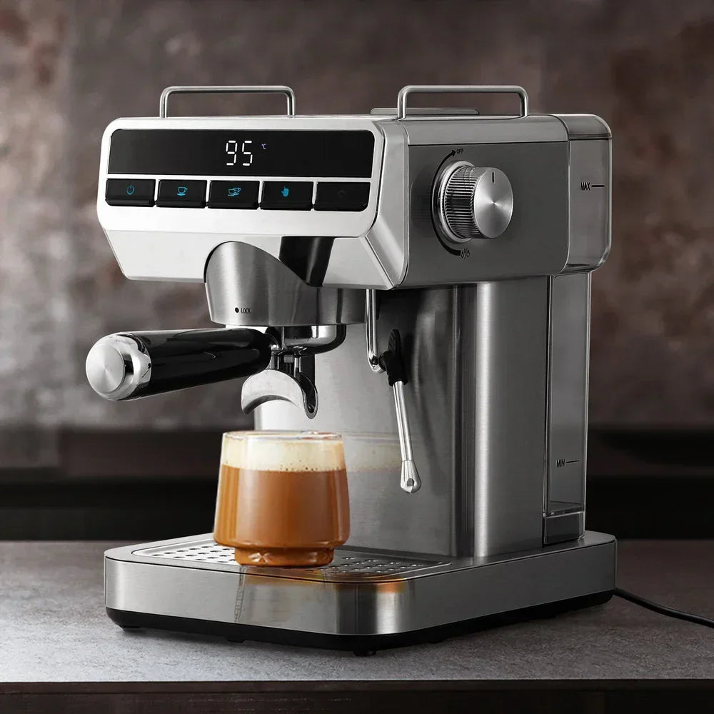 Stainless steel espresso machine brewing coffee into a glass cup on a kitchen counter