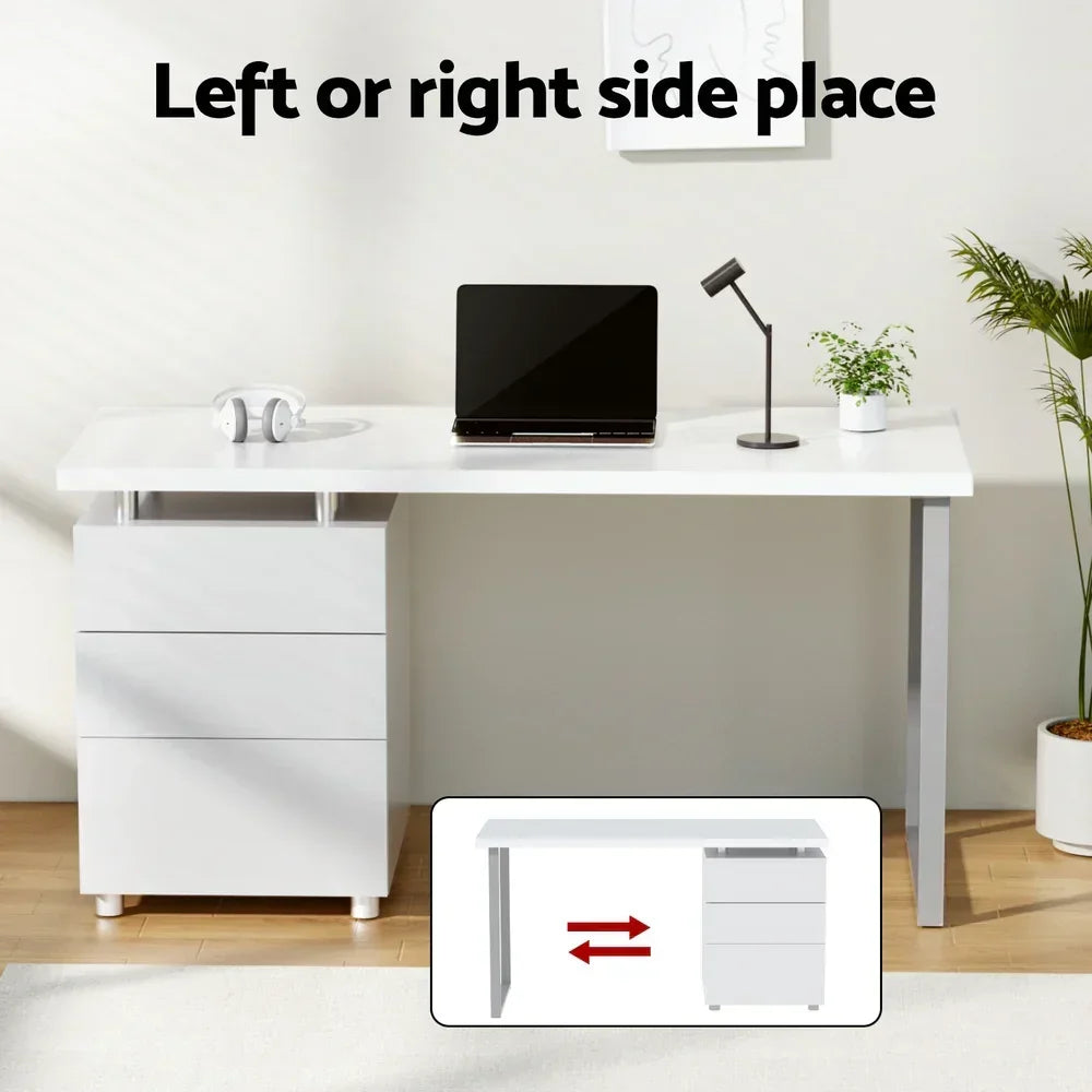 Modern white office desk with drawers, laptop, lamp, and plants, reversible drawer setup