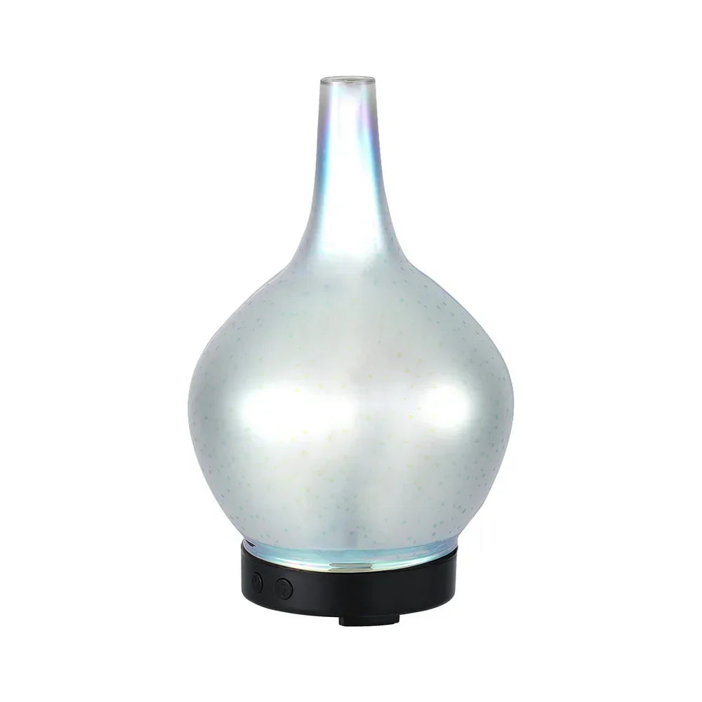 Modern glass essential oil diffuser with iridescent finish and black base on white background
