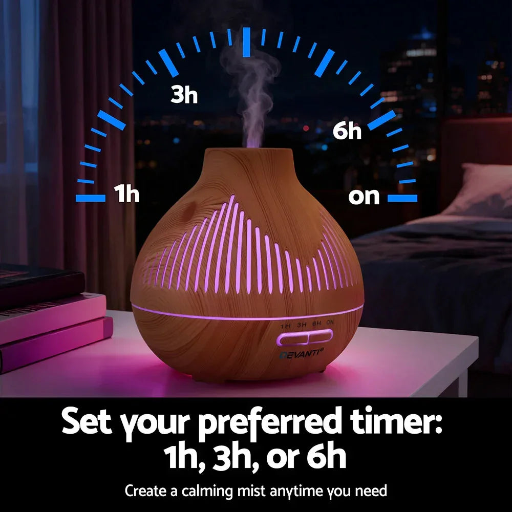 Wood grain essential oil diffuser with LED lights and timer settings on bedside table at night