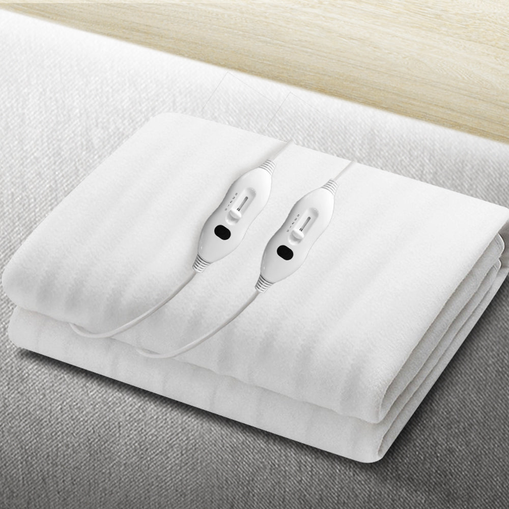 White electric blanket with dual controllers on a light-colored bed surface