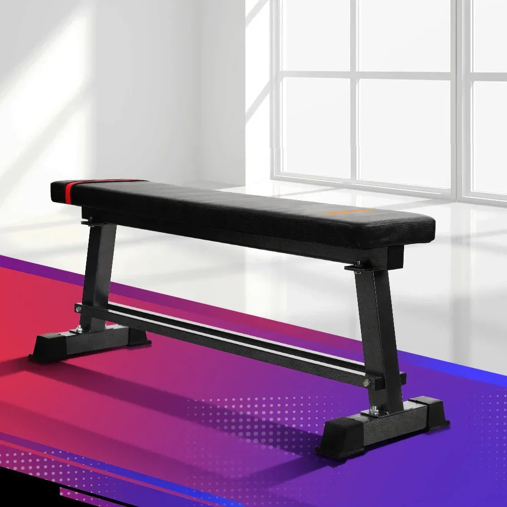 Flat weight bench with black padded surface and sturdy metal frame in a modern room