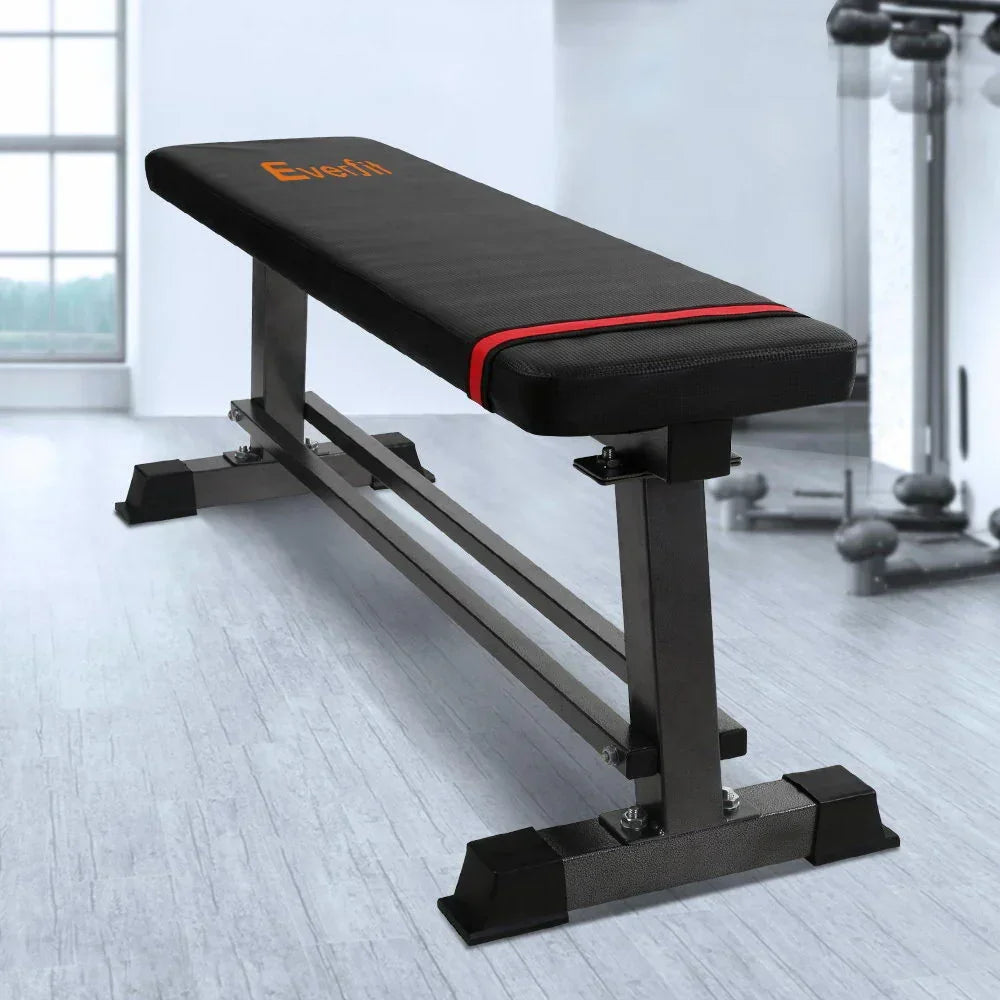 Flat weight bench with black padded surface and sturdy steel frame in a home gym setting