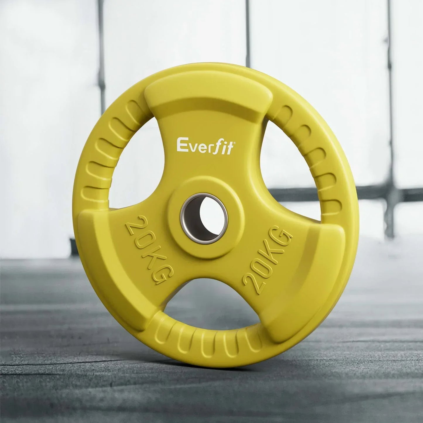 Yellow 20kg Everfit weight plate with hand grips on gym floor