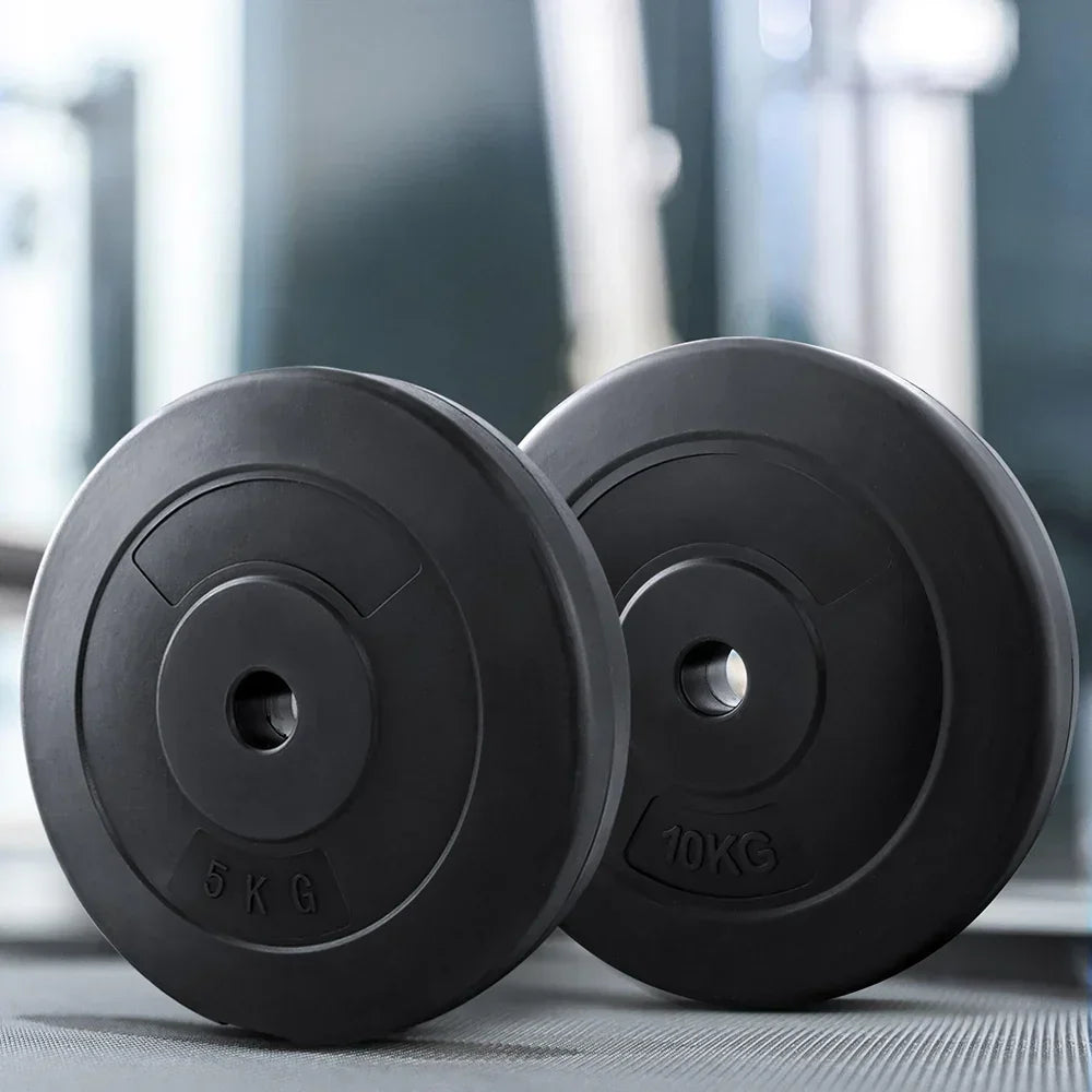 Black 5kg and 10kg weight plates on gym floor, fitness equipment for strength training