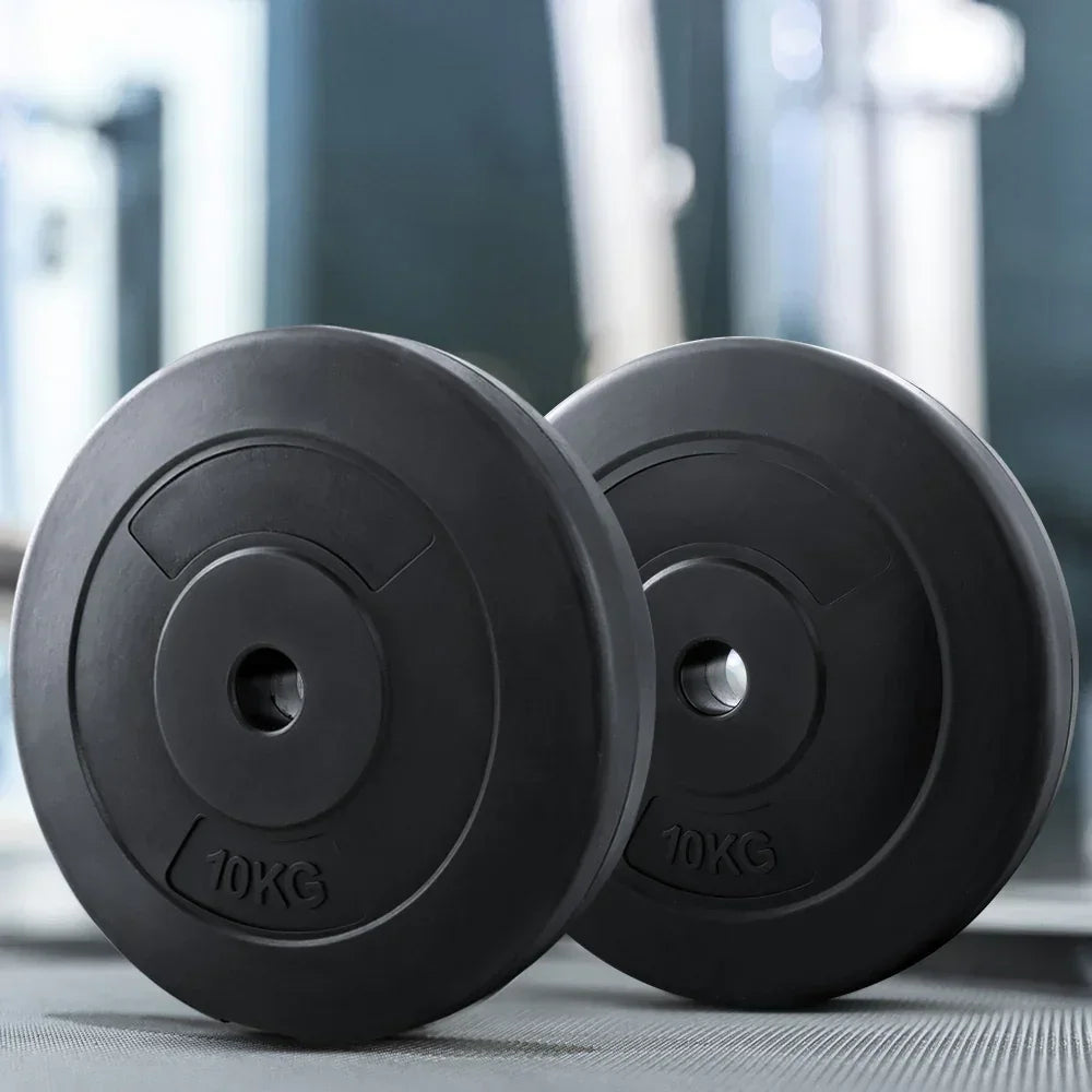 Pair of 10kg black weight plates on gym floor, fitness equipment