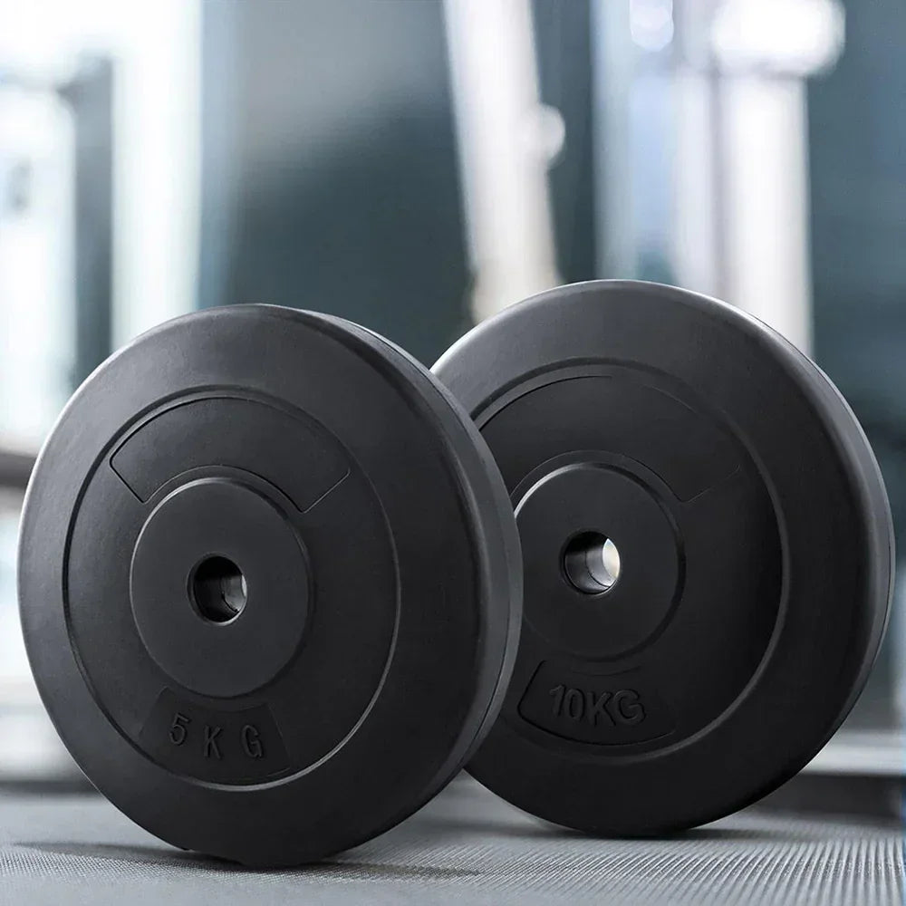 Black weight plates 5kg and 10kg on gym floor, fitness equipment for strength training