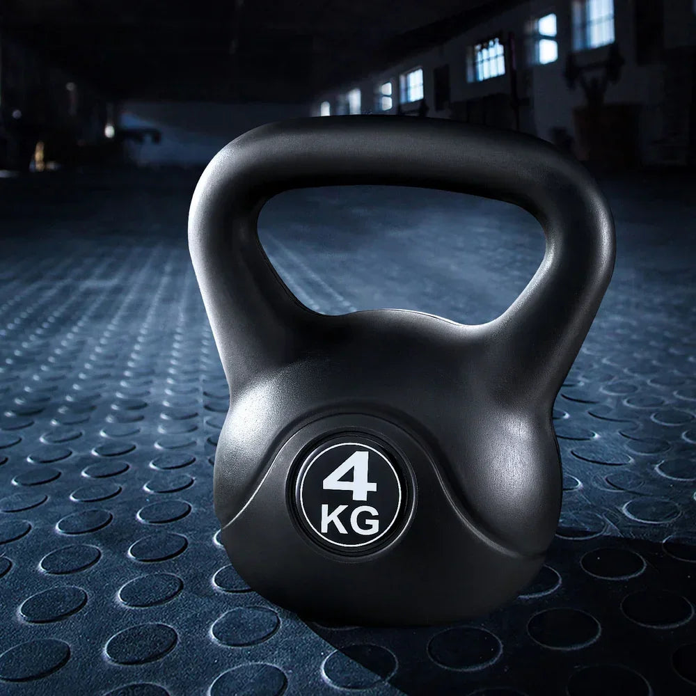 Black 4kg kettlebell on textured gym floor, ideal for strength training workouts