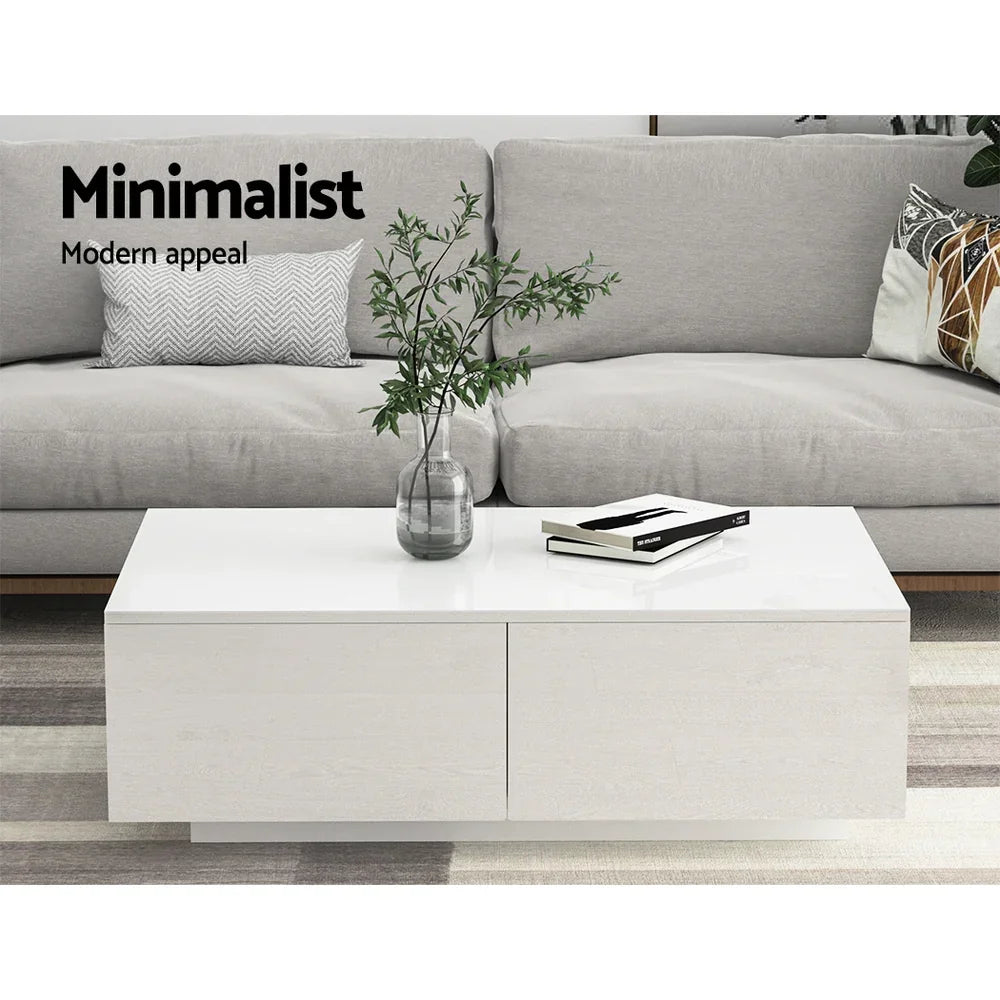 White minimalist coffee table with storage drawers in front of a light grey sofa, modern decor