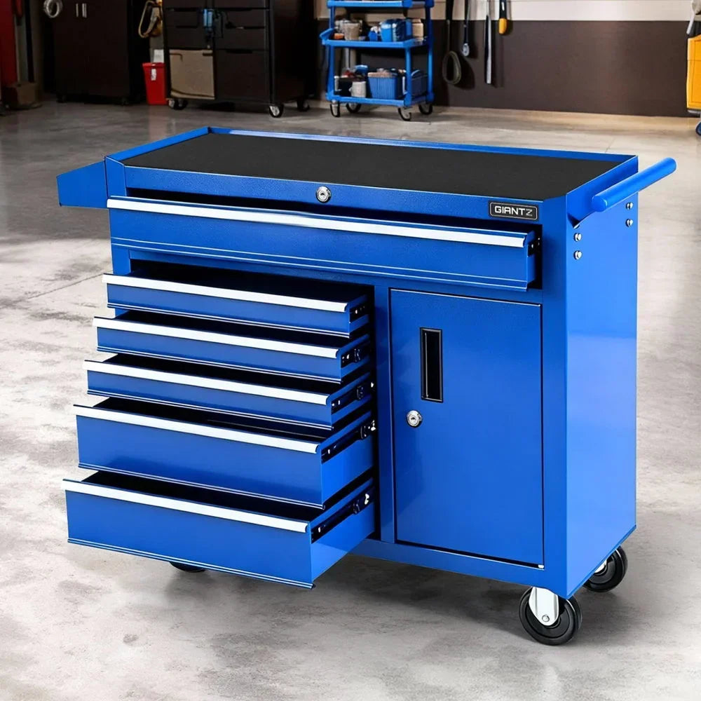 Blue mobile tool chest with multiple open drawers and sturdy wheels in a workshop setting