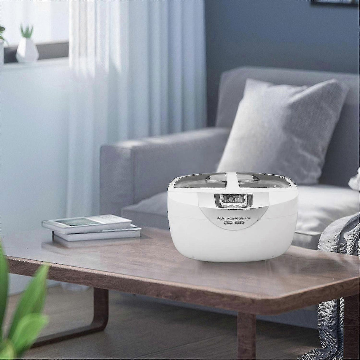 White digital ultrasonic cleaner on wooden table in modern living room