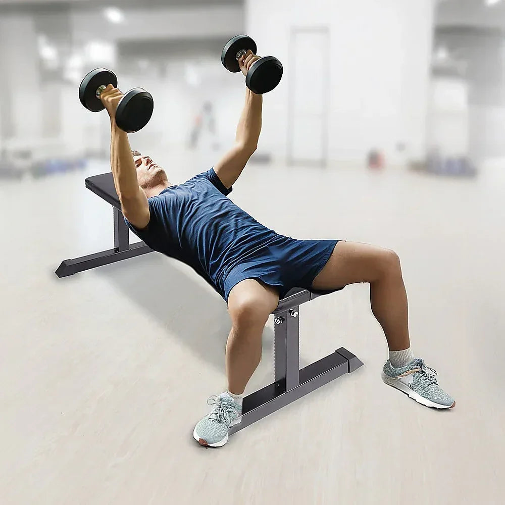 Man in gym performing dumbbell press on weight bench, fitness workout equipment