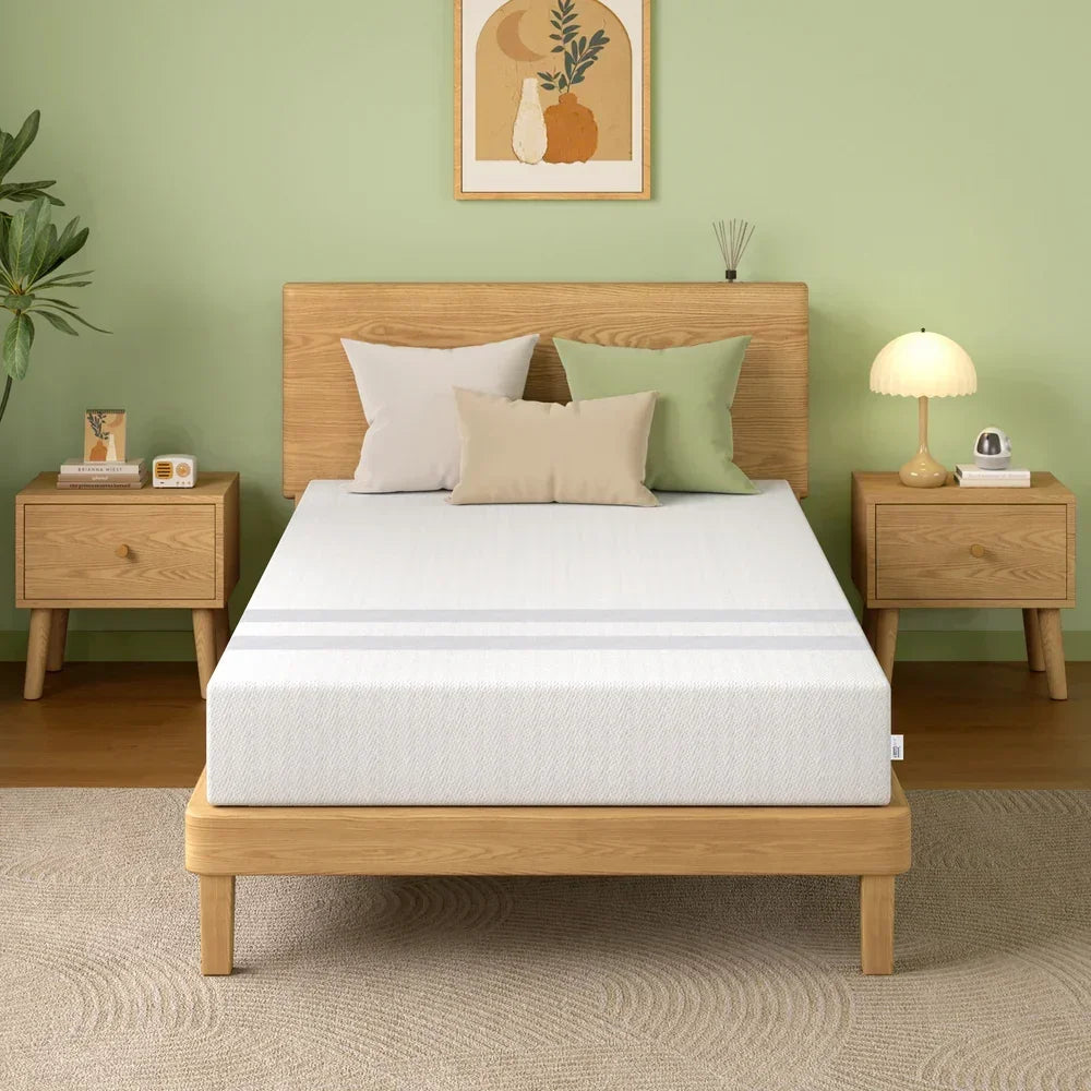 Minimalist bedroom with wooden bed frame, white mattress, green and beige pillows, green walls, and matching nightstands