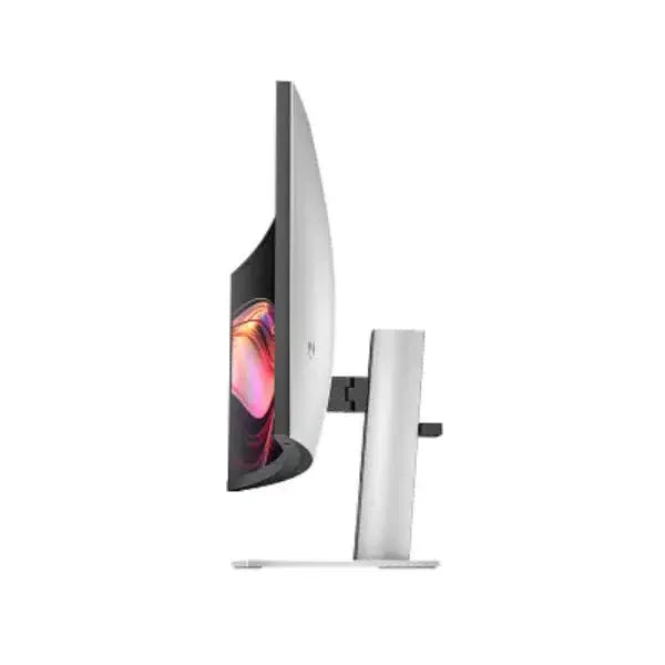 Side view of a curved computer monitor with slim bezel and silver stand on white background