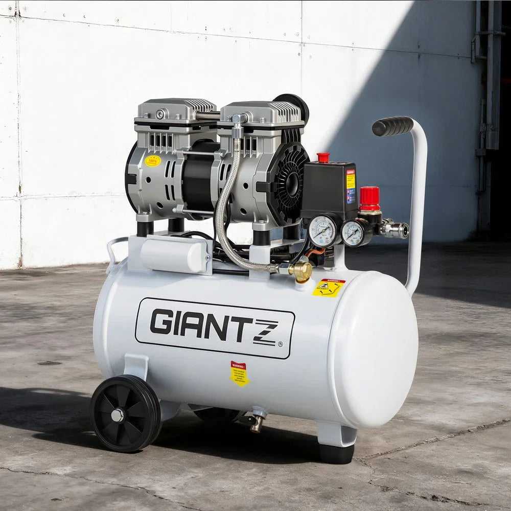 Industrial portable air compressor with pressure gauges and wheels on concrete floor