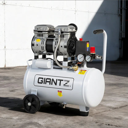 Industrial portable air compressor with pressure gauges and wheels on concrete floor