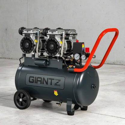 Industrial air compressor with twin motors, large tank, control gauges, and orange handle