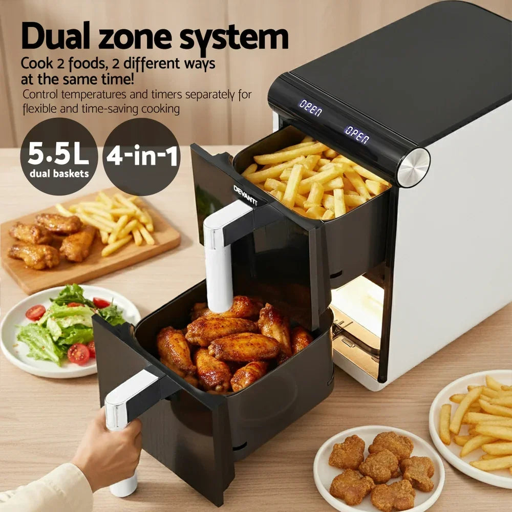 Dual zone air fryer with two baskets cooking fries and chicken wings, food on table