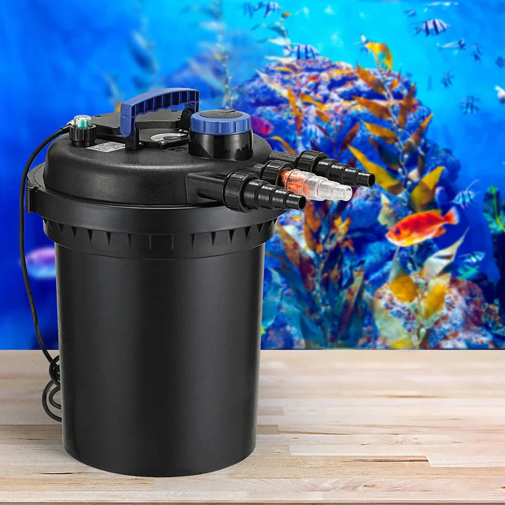 Black aquarium canister filter with multiple hose connectors on a wooden table, aquarium backdrop