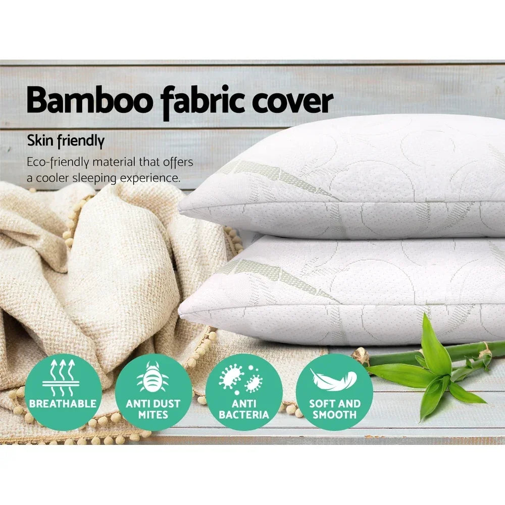 Two white bamboo fabric pillows on beige throw, labeled breathable, anti-dust mite, antibacterial, soft.