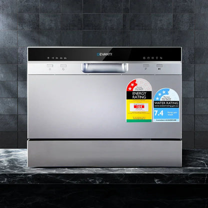 Countertop stainless steel dishwasher with energy and water rating labels, modern kitchen setting
