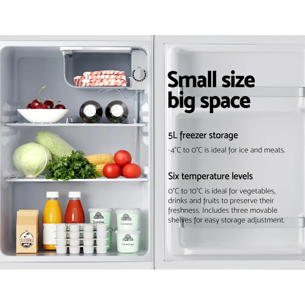 Compact refrigerator with organized shelves holding fruits, vegetables, drinks, and dairy inside.