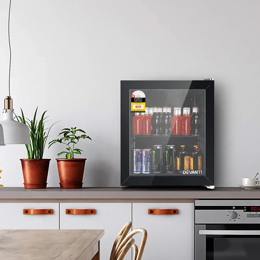 Kitchen scene with small glass door bar fridge filled with assorted drinks on a countertop