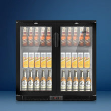 Glass door bar fridge with assorted bottled and canned drinks on display against blue background