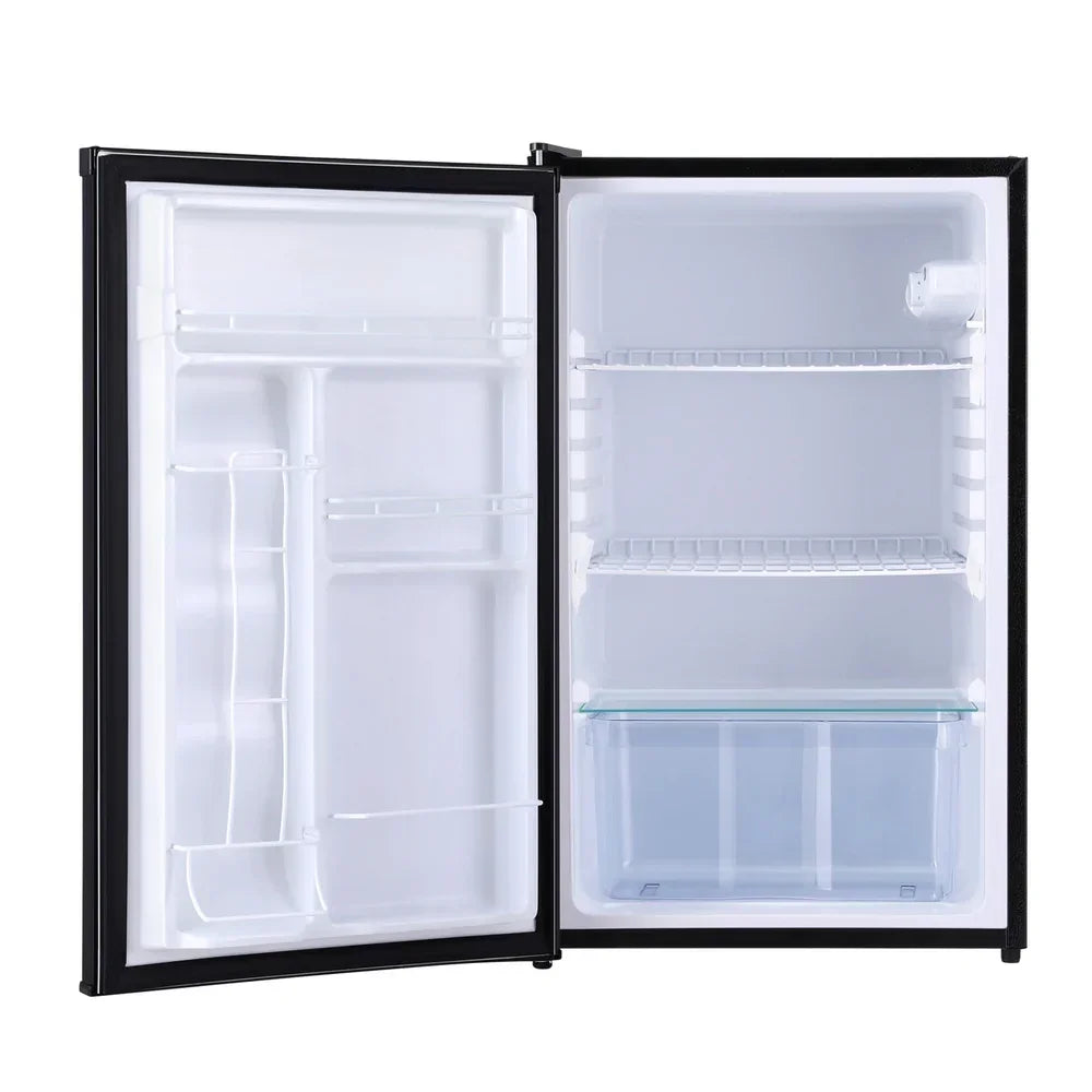 Open compact fridge with empty shelves and clear crisper drawer, white interior