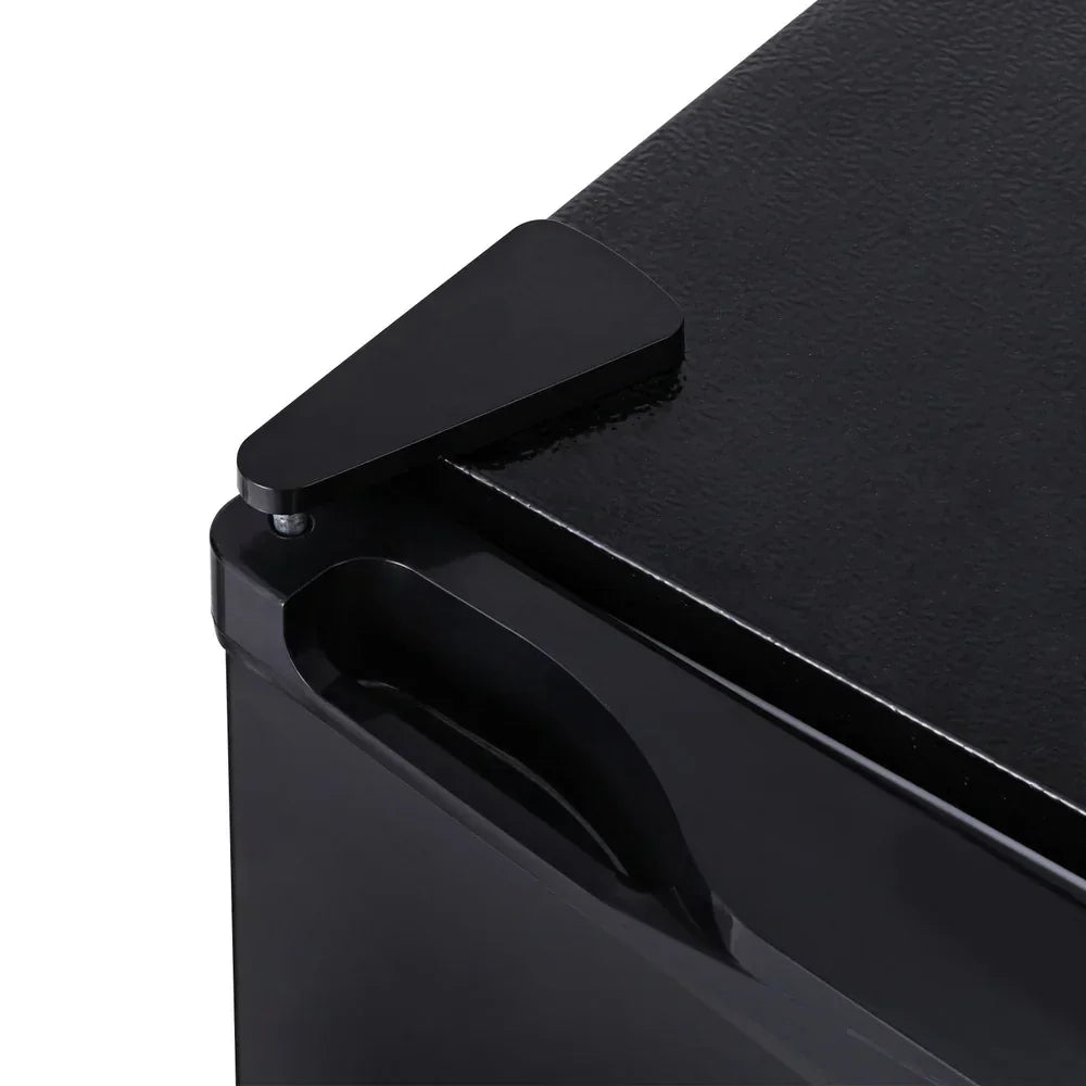 Close-up of a black metal cabinet corner with a triangular corner protector and side handle