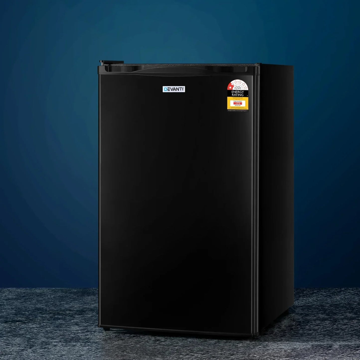 Black compact mini fridge with energy rating sticker on a textured surface, blue background.