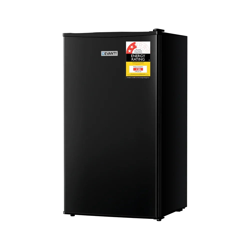 Black mini fridge with energy rating sticker on door, freestanding compact refrigerator.