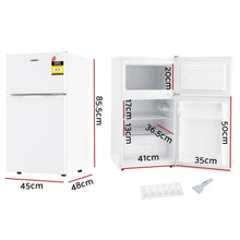 White compact bar fridge with freezer, doors open showing interior shelves, labelled dimensions.