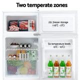 Compact fridge freezer with two temperature zones, showing organized food and drinks storage.