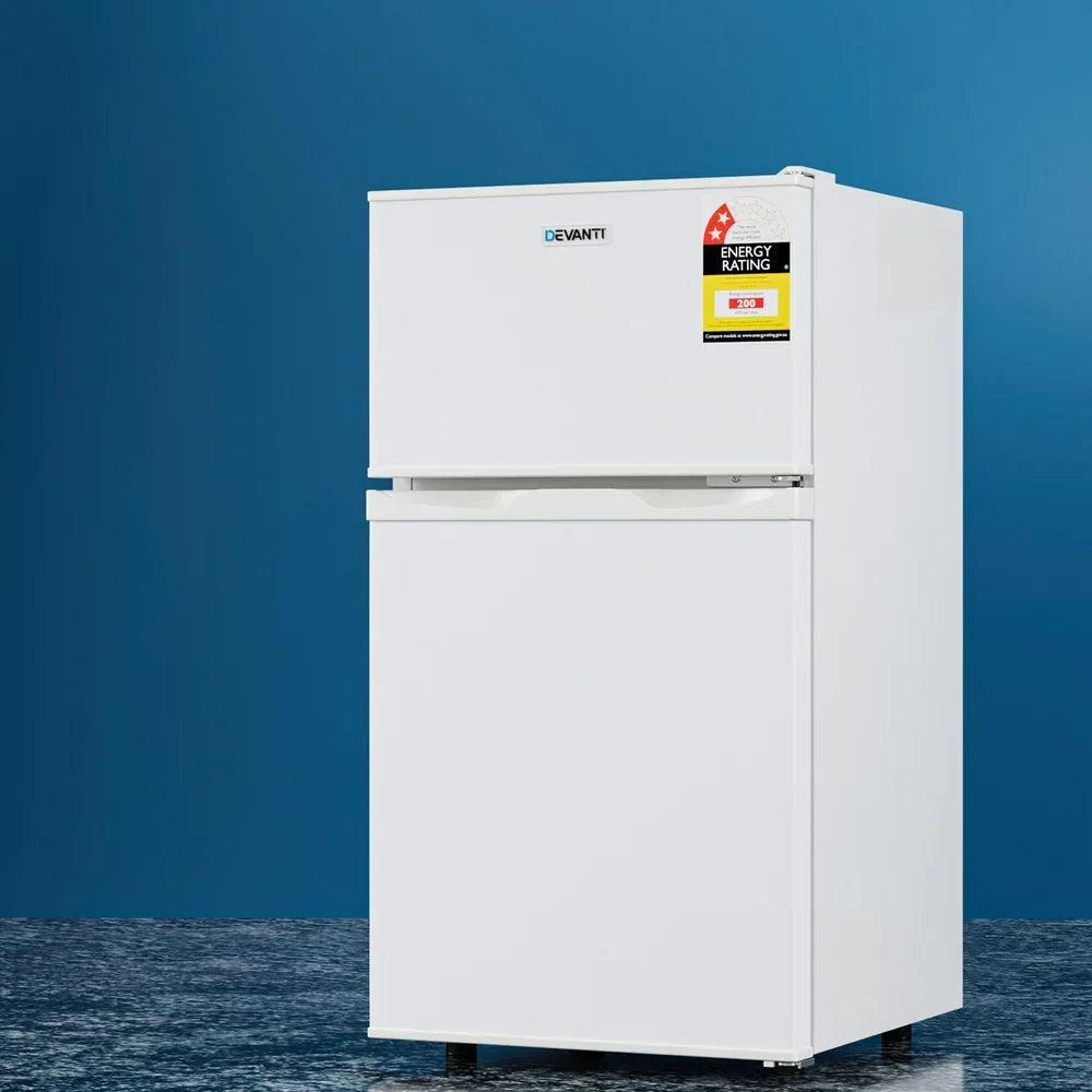 White two door fridge freezer with energy rating label, standing on blue background