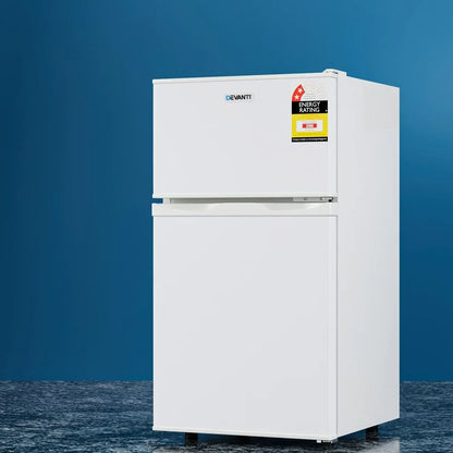 White two door fridge freezer with energy rating label, standing on blue background