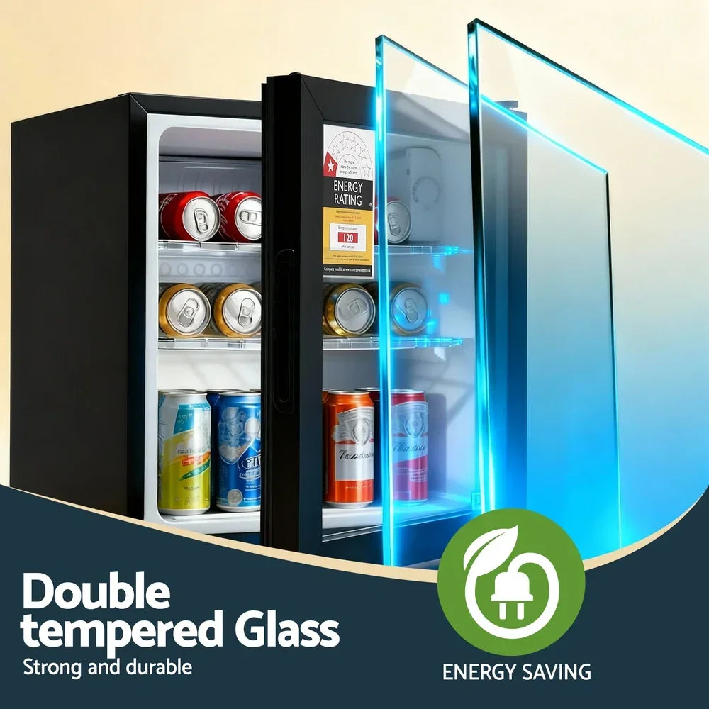Black mini fridge with double tempered glass door, energy rating label, and assorted drink cans inside.