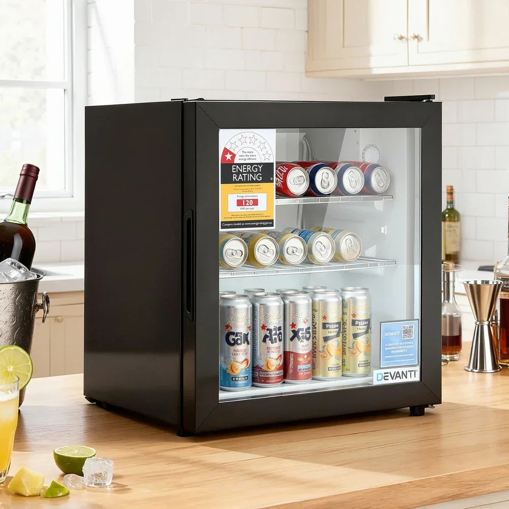Black glass door bar fridge filled with assorted drink cans on a kitchen countertop