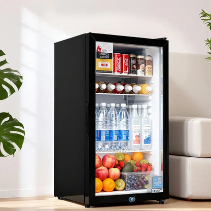 Black glass door mini fridge filled with drinks, bottled water, and assorted fresh fruit in a modern room
