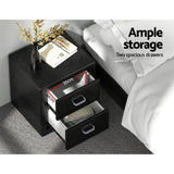 Black bedside table with two spacious drawers, vase, books, and storage dimensions shown.