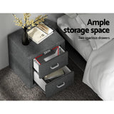 Grey bedside table with two open drawers, vase, books on top, next to a bed, showing drawer dimensions.