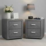 Pair of modern grey fabric bedside tables with drawers, flowers, lamp, books, and clock