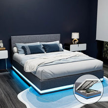 Modern grey upholstered bed frame with LED lighting and gas lift storage in a stylish bedroom.
