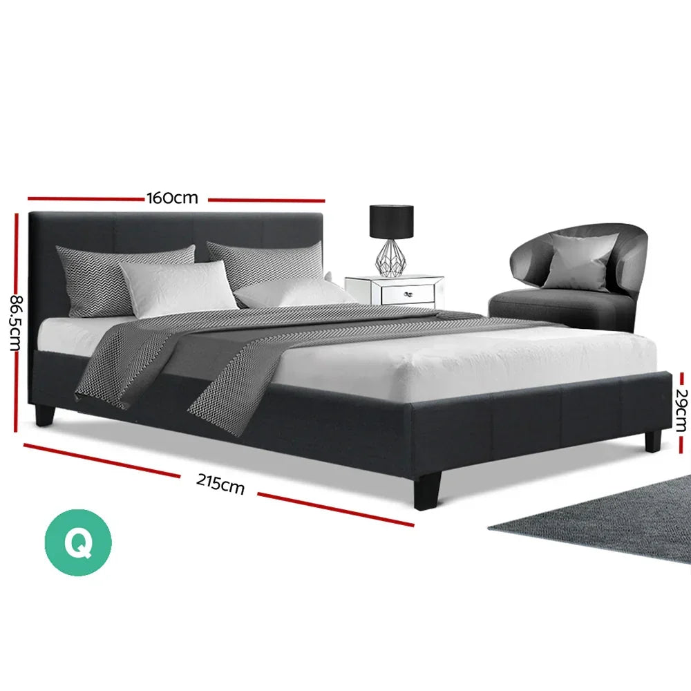 Modern queen bed frame in dark fabric with dimensions, next to nightstand and armchair