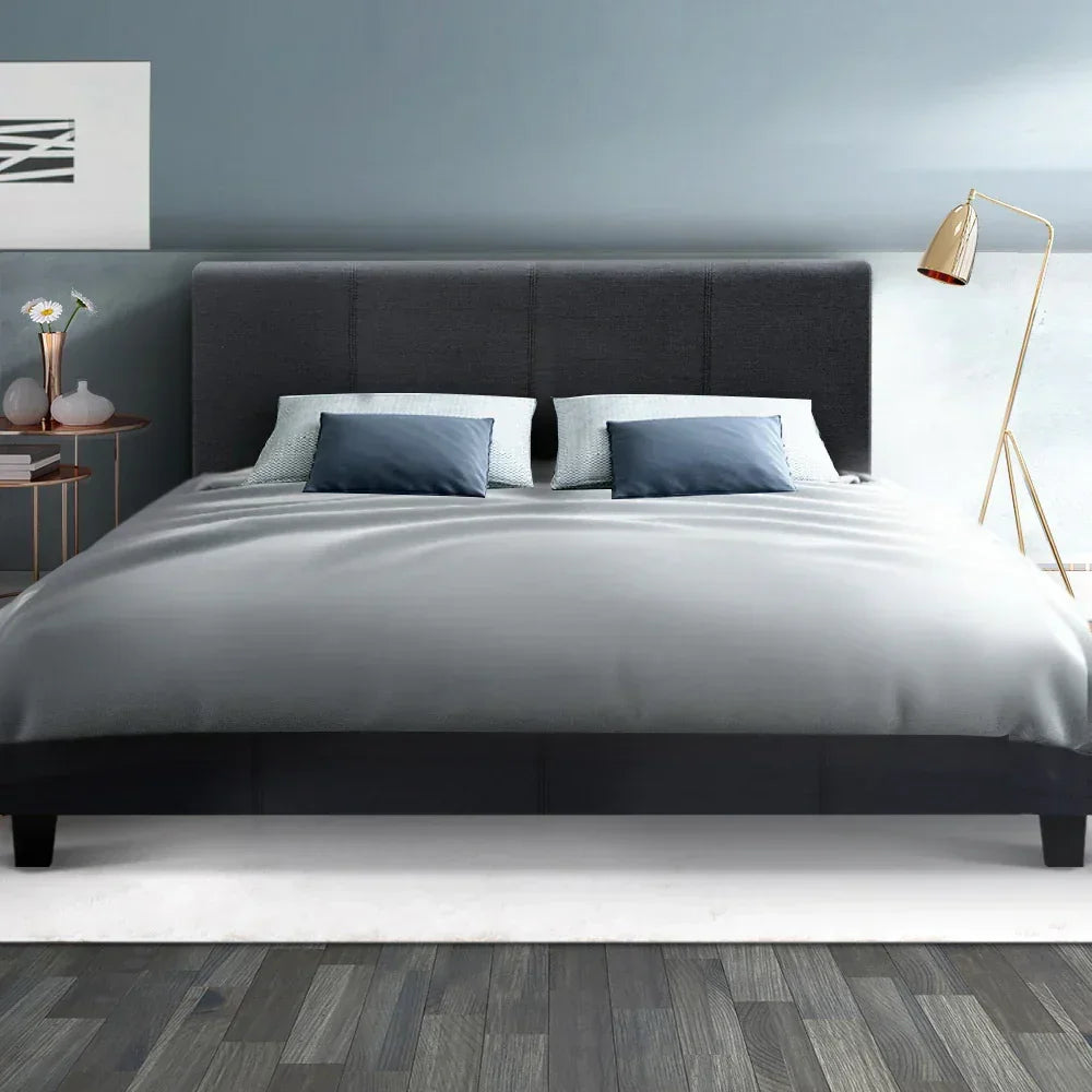 Modern queen bed with grey upholstered headboard, grey bedding, and blue accent pillows