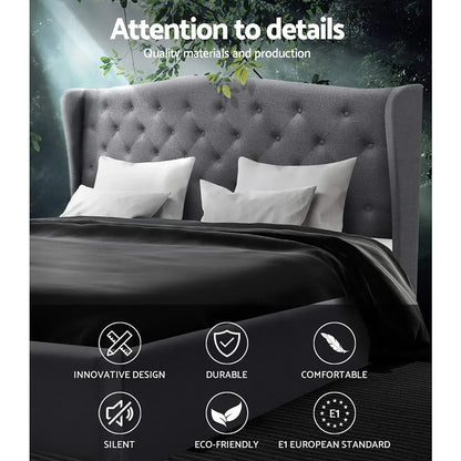 Gray tufted bed frame with wingback headboard, white pillows, black bedding, and icon features